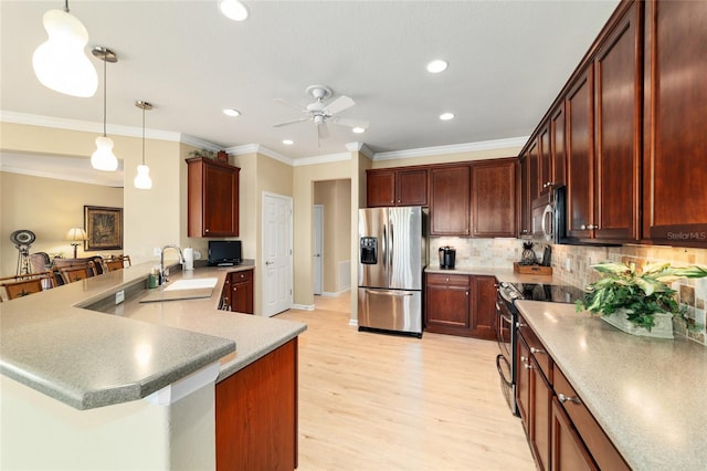 kitchen featuring stainless steel appliances, a sink, light wood-type flooring, a peninsula, and ceiling fan
