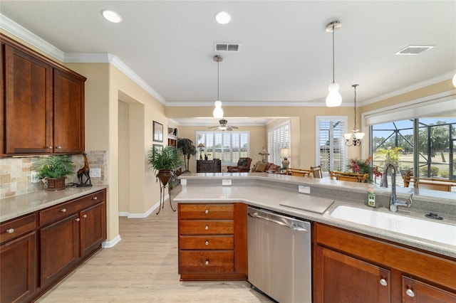 kitchen with a sink, visible vents, dishwasher, light countertops, and hanging light fixtures