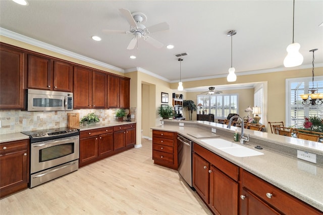 kitchen featuring stainless steel appliances, visible vents, a sink, light wood-style flooring, and ceiling fan with notable chandelier