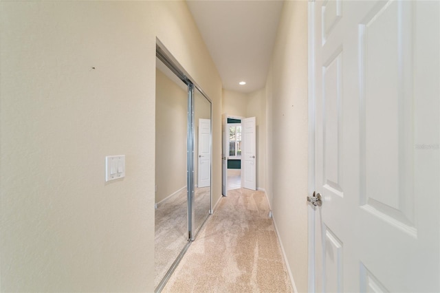 hall with baseboards, recessed lighting, and light colored carpet