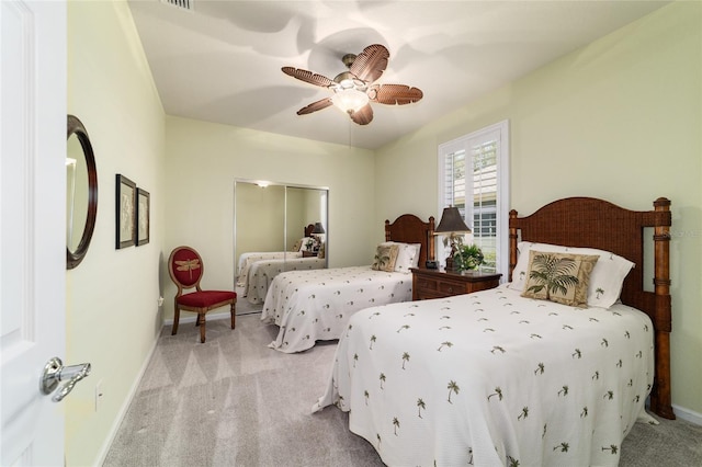 bedroom featuring light carpet, a ceiling fan, and baseboards