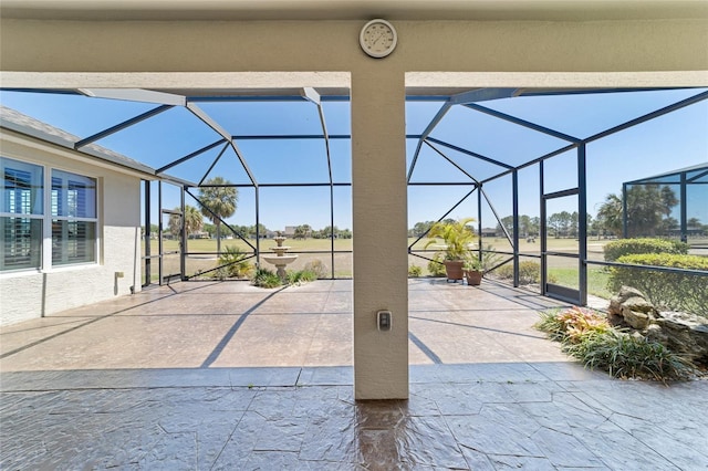 view of patio featuring glass enclosure