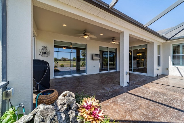 exterior space featuring grilling area, a ceiling fan, and glass enclosure