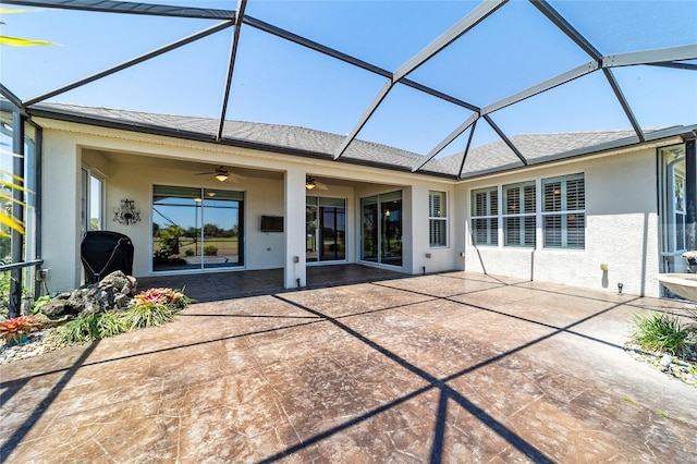 rear view of property featuring a patio area, a ceiling fan, a shingled roof, and stucco siding