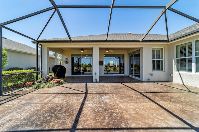 back of property featuring a shingled roof, stucco siding, ceiling fan, a patio area, and a lanai