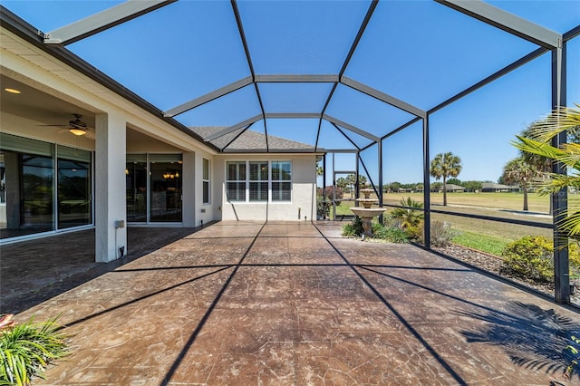 unfurnished sunroom featuring ceiling fan