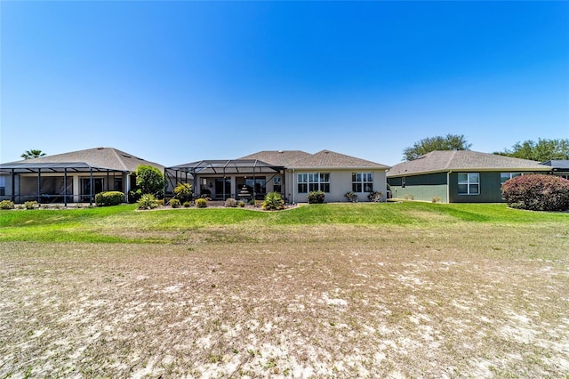 rear view of property with a lawn and a lanai
