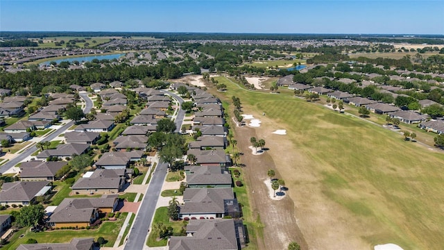 birds eye view of property with view of golf course, a residential view, and a water view