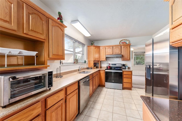 kitchen featuring a sink, light tile patterned flooring, a toaster, stainless steel appliances, and under cabinet range hood