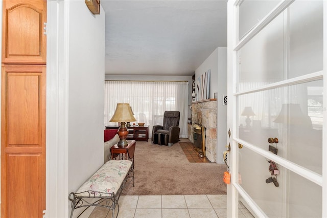 living area featuring a fireplace, light colored carpet, and light tile patterned floors