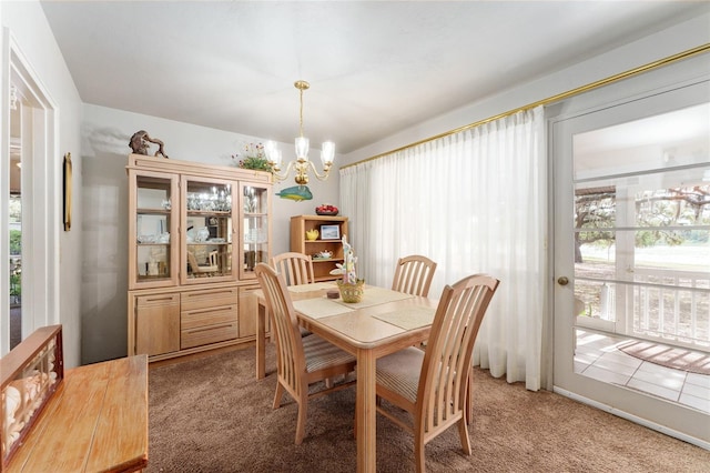 dining area with light carpet, a notable chandelier, and plenty of natural light