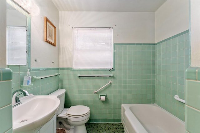 bathroom with tile patterned flooring, toilet, tile walls, wainscoting, and a bathtub