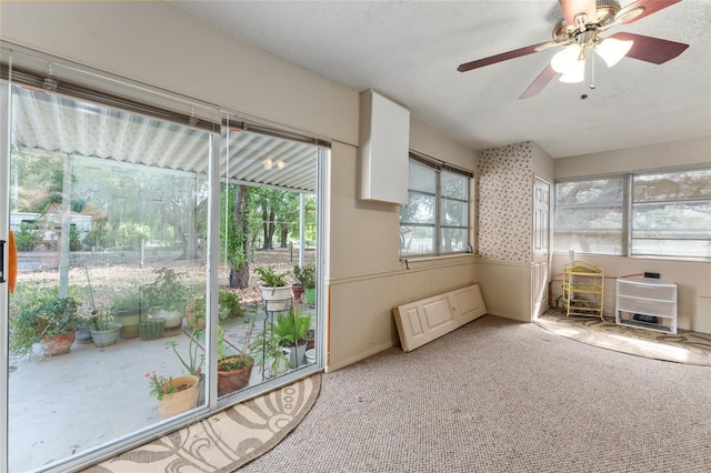 unfurnished sunroom featuring a ceiling fan