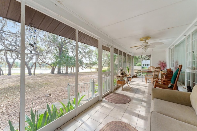 sunroom / solarium featuring a ceiling fan and a water view