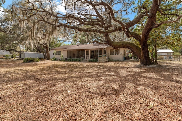 rear view of property featuring a sunroom