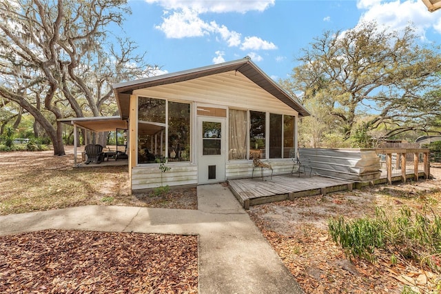 exterior space with a wooden deck and a sunroom