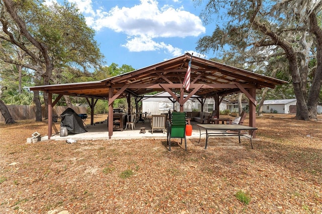 view of community with a gazebo, a patio area, and fence