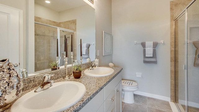 full bathroom featuring toilet, double vanity, a sink, and a stall shower