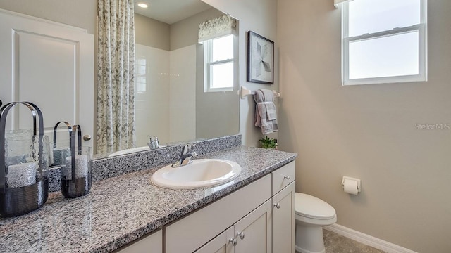 bathroom featuring curtained shower, vanity, baseboards, and toilet