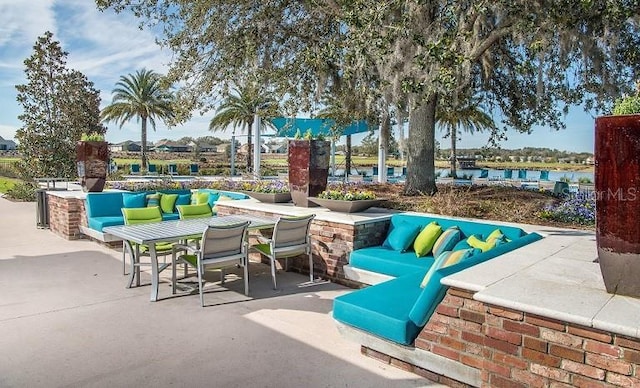 view of patio / terrace with a water view, outdoor dining area, and an outdoor hangout area