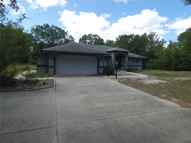 ranch-style home with a garage, roof with shingles, driveway, and stucco siding
