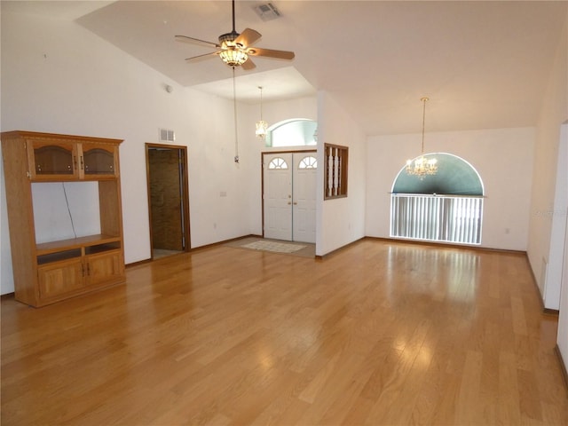 foyer entrance featuring light wood-style floors, ceiling fan with notable chandelier, high vaulted ceiling, and visible vents