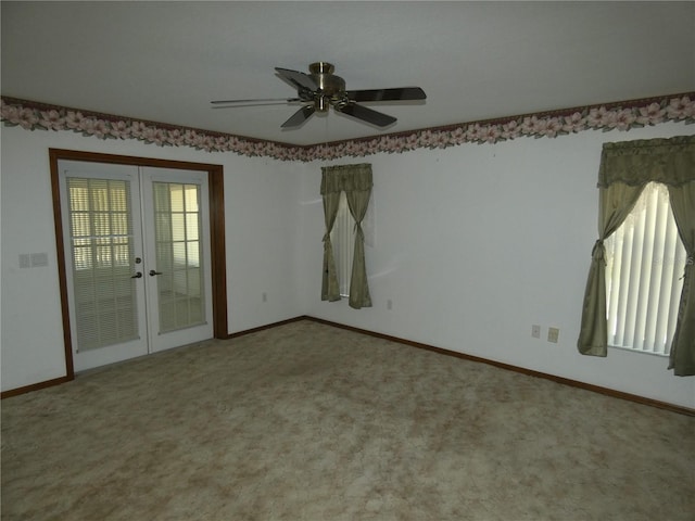 carpeted spare room featuring french doors, baseboards, and a ceiling fan
