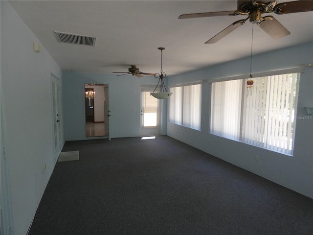 empty room with carpet flooring, visible vents, and a ceiling fan