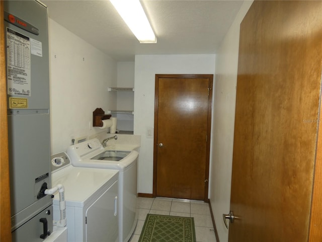 laundry area with heating unit, light tile patterned flooring, washer and clothes dryer, laundry area, and a sink
