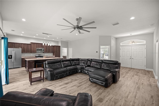living room featuring a ceiling fan, visible vents, recessed lighting, and light wood-style floors