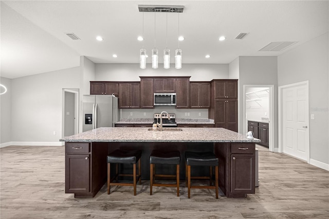 kitchen featuring a large island with sink, a sink, baseboards, visible vents, and appliances with stainless steel finishes