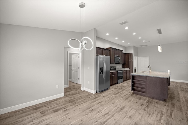 kitchen with stainless steel appliances, dark brown cabinets, a sink, baseboards, and light wood-style flooring