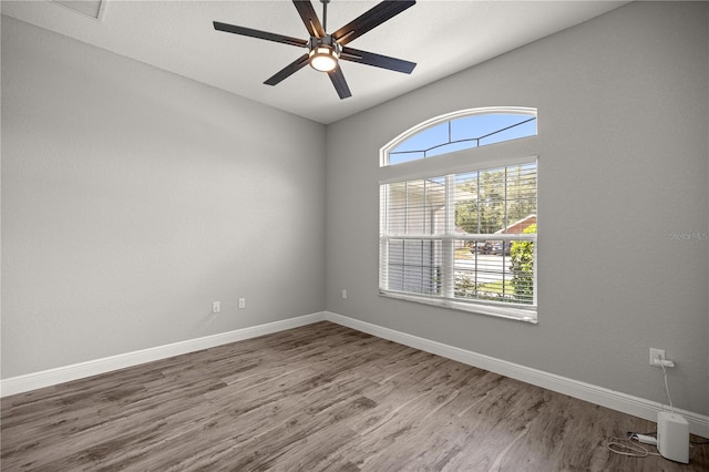 unfurnished room with visible vents, baseboards, wood finished floors, and ceiling fan