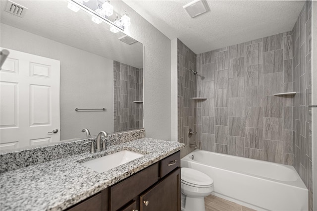 bathroom with a textured ceiling, toilet, visible vents, vanity, and tub / shower combination