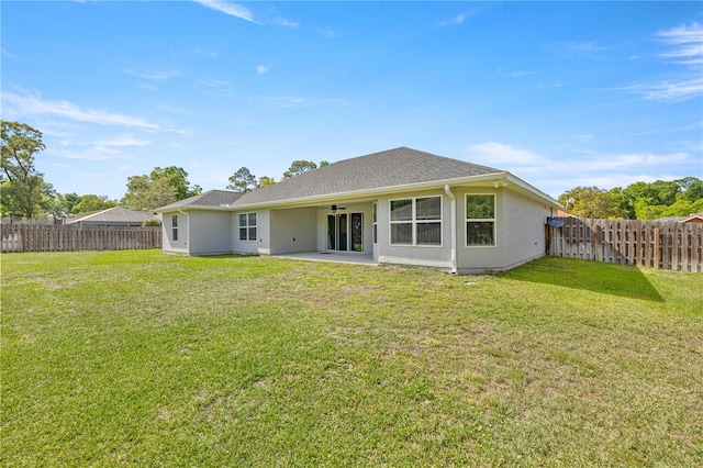 rear view of house with a lawn, a patio, a fenced backyard, and ceiling fan
