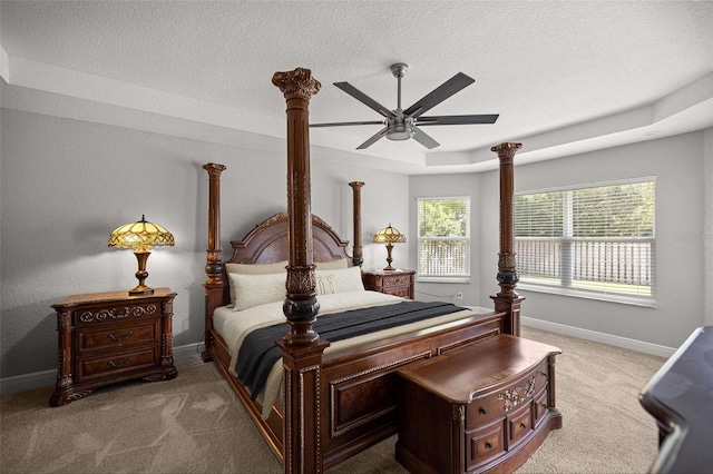 carpeted bedroom with a textured ceiling, a ceiling fan, and baseboards