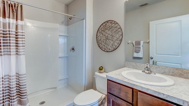 full bath featuring visible vents, toilet, a shower with shower curtain, and vanity