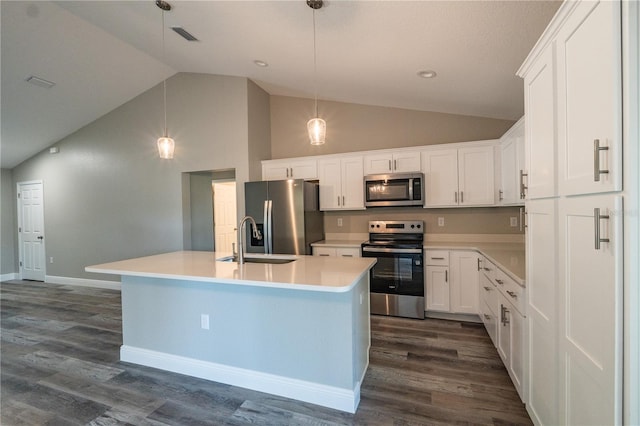 kitchen with a sink, dark wood finished floors, appliances with stainless steel finishes, and lofted ceiling