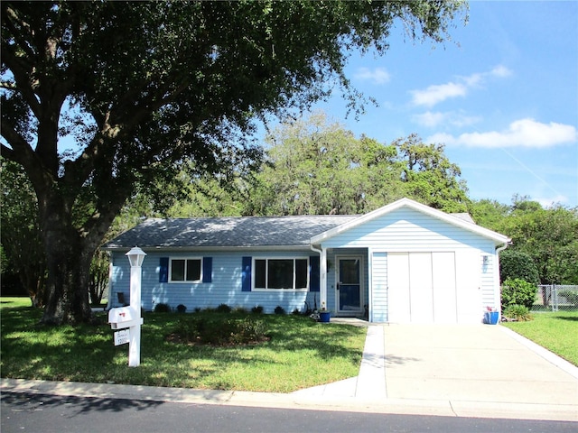 ranch-style home featuring an attached garage, a front yard, concrete driveway, and fence