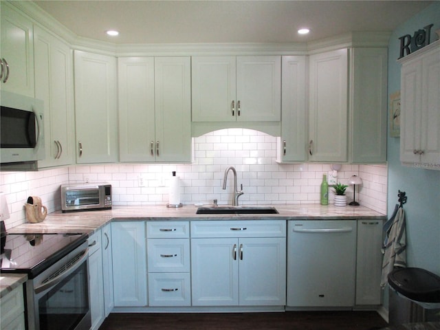 kitchen featuring a toaster, a sink, white dishwasher, decorative backsplash, and stainless steel electric range oven