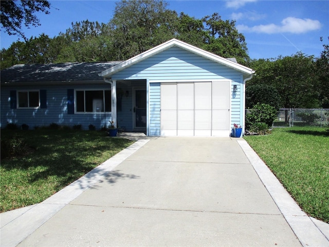 ranch-style home featuring a garage, a front lawn, concrete driveway, and fence