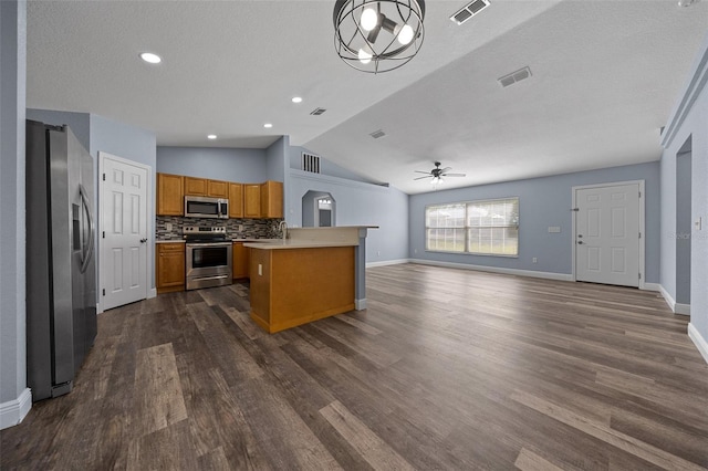 2312 SW 140th Ct, Ocala, FL 34481 - kitchen featuring appliances with stainless steel finishes, open floor plan, ceiling fan, brown cabinets, and lofted ceiling