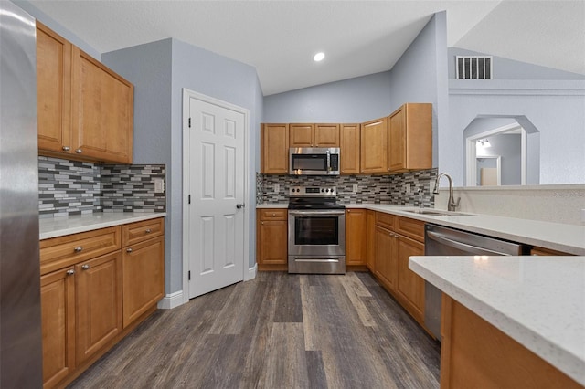 2312 SW 140th Ct, Ocala, FL 34481 - kitchen with stainless steel appliances, a sink, dark wood finished floors, vaulted ceiling, and tasteful backsplash