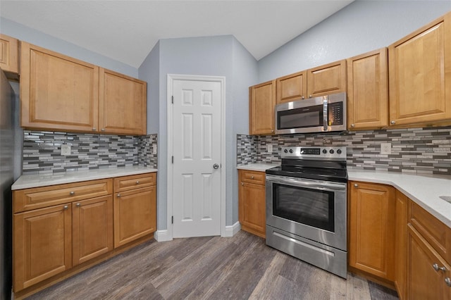 2312 SW 140th Ct, Ocala, FL 34481 - kitchen with stainless steel appliances, dark wood-style floors, light countertops, backsplash, and vaulted ceiling