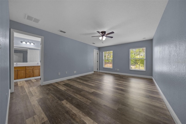2312 SW 140th Ct, Ocala, FL 34481 - unfurnished bedroom featuring a textured wall, dark wood-style flooring, baseboards, connected bathroom, and ceiling fan