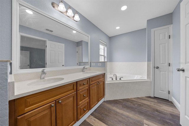 2312 SW 140th Ct, Ocala, FL 34481 - full bath featuring wood finished floors, double vanity, and a garden tub