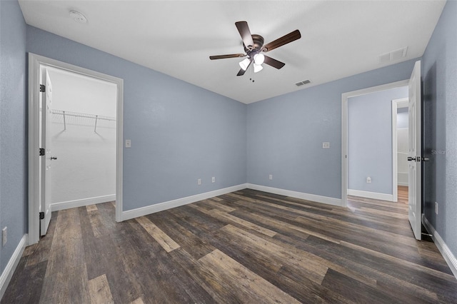 2312 SW 140th Ct, Ocala, FL 34481 - unfurnished bedroom with dark wood-style floors, a walk in closet, baseboards, and a ceiling fan