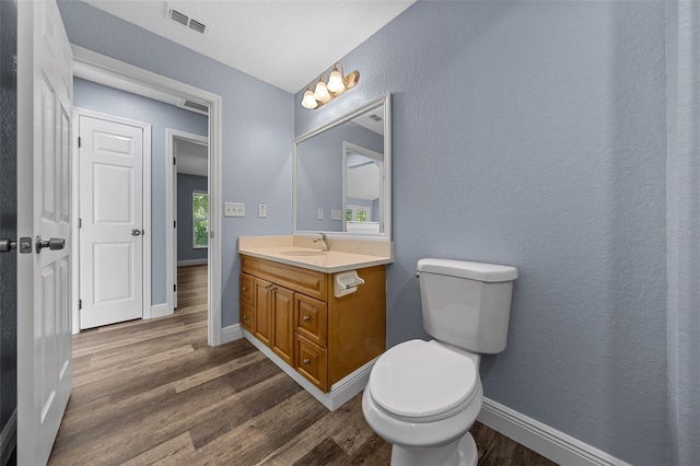 2312 SW 140th Ct, Ocala, FL 34481 - bathroom featuring vanity, toilet, wood finished floors, baseboards, and a textured wall