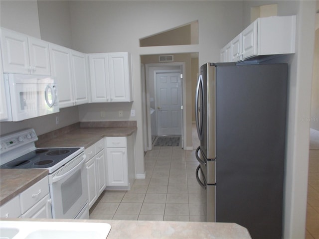 11653 SW 72nd Cir, Ocala, FL 34476 - kitchen featuring white appliances, light tile patterned flooring, white cabinetry, and light countertops
