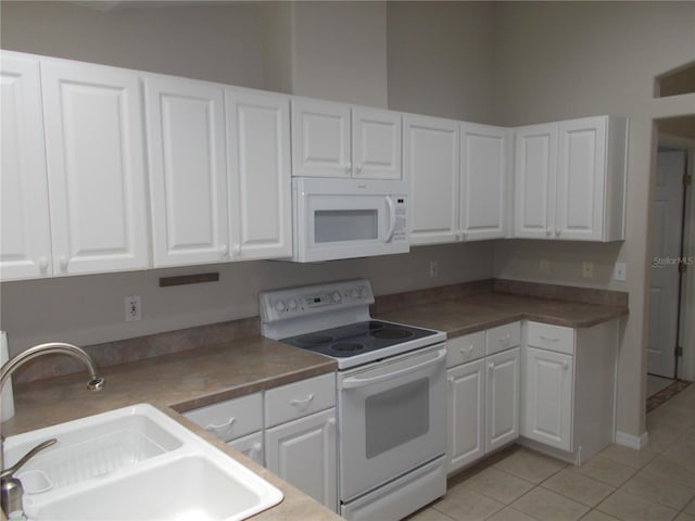 11653 SW 72nd Cir, Ocala, FL 34476 - kitchen with white appliances, a sink, light tile patterned flooring, and white cabinetry